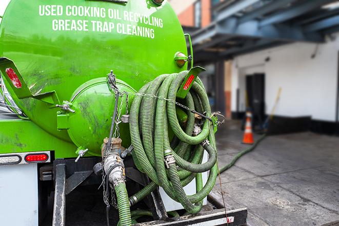 a technician pumping a grease trap in a commercial building in Affton, MO